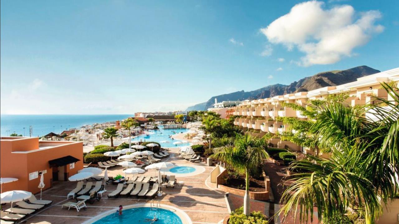 A sunny resort on the Spanish coast with pool, palms and sea views, the reward for planning a move to Spain correctly